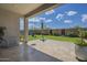 Relaxing backyard with travertine patio, swing, umbrella, and view of the blue sky at 10509 W Harmony Ln, Peoria, AZ 85382