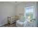 Cozy Bedroom with white crib, comfortable chair, and natural light at 10509 W Harmony Ln, Peoria, AZ 85382