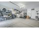 A spacious, organized three-car garage, with storage racks, work out equipment, and room for vehicles at 10509 W Harmony Ln, Peoria, AZ 85382