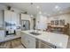 Modern kitchen with stainless steel appliances, a large island, and white cabinets for storage at 10509 W Harmony Ln, Peoria, AZ 85382