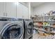 Laundry room equipped with washer and dryer, ample storage and shelving at 10509 W Harmony Ln, Peoria, AZ 85382