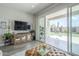 Bright living room with sliding glass doors leading to a landscaped backyard and entertainment space at 10509 W Harmony Ln, Peoria, AZ 85382