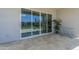 A covered patio with travertine flooring and large sliding glass doors, leading to a lush backyard at 10509 W Harmony Ln, Peoria, AZ 85382