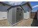 Backyard storage shed with modern gray siding and classic double-door design provides space for outdoor equipment at 10509 W Harmony Ln, Peoria, AZ 85382