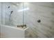 Modern shower featuring white marble-look tiles, glass enclosure, and sleek fixtures at 10509 W Harmony Ln, Peoria, AZ 85382