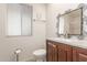 Well-lit bathroom with decorative mirror and a wooden vanity at 10724 W Cheryl Dr, Sun City, AZ 85351