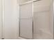 Bright bathroom shower featuring a sliding door and a built-in seat at 10724 W Cheryl Dr, Sun City, AZ 85351