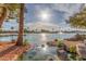 Scenic community lake view with fountain, palm trees, rock landscaping, and blue skies with sunshine at 10724 W Cheryl Dr, Sun City, AZ 85351