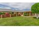 Landscaped front yard with lush green lawn, brick accents, and mature tree at 10724 W Cheryl Dr, Sun City, AZ 85351