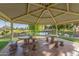 Gazebo in a park-like setting with stone tables and benches overlooking a serene lake and lush greenery at 10724 W Cheryl Dr, Sun City, AZ 85351