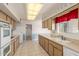 The kitchen features tile flooring, garden window, white appliances, and plenty of storage at 10724 W Cheryl Dr, Sun City, AZ 85351