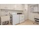 Laundry room with washer, dryer, utility sink, and white cabinets for storage at 10724 W Cheryl Dr, Sun City, AZ 85351