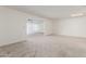 Bright living room boasts neutral carpet, white walls, and a large window at 10724 W Cheryl Dr, Sun City, AZ 85351