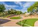 Scenic miniature golf course featuring red rock landscaping, mature shade trees, and bright green turf at 10724 W Cheryl Dr, Sun City, AZ 85351