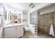 Bright bathroom with glass block shower, white vanity, and tiled floors at 10827 W Santa Fe Dr, Sun City, AZ 85351