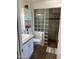 Bright bathroom featuring tile flooring, a sink, and a glass block shower wall at 10827 W Santa Fe Dr, Sun City, AZ 85351