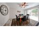 A dining room with a ceiling fan, tiled floors, and a dark wood table with chairs set on a decorative area rug at 10827 W Santa Fe Dr, Sun City, AZ 85351