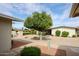 Charming front yard landscaping featuring a beautiful shade tree and rock ground cover at 10827 W Santa Fe Dr, Sun City, AZ 85351