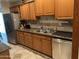 Kitchen features stainless steel appliances, wood cabinets, granite countertops and tile backsplash at 10827 W Santa Fe Dr, Sun City, AZ 85351