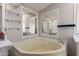 Bathroom with a corner soaking tub, vanity with sink, and decorative mirrors at 10951 N 91St Ave # 222, Peoria, AZ 85345