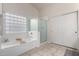 Clean bathroom featuring a soaking tub, glass block window, and separate shower at 11402 W Hadley St, Avondale, AZ 85323