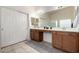 Bright bathroom featuring double sinks, tile floors, and enclosed shower at 11402 W Hadley St, Avondale, AZ 85323