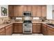 Well-lit kitchen featuring stainless steel appliances, and wooden cabinets at 11402 W Hadley St, Avondale, AZ 85323