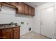 Functional laundry room with a stainless steel sink, cabinets, and convenient washer/dryer hookups at 11402 W Hadley St, Avondale, AZ 85323
