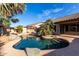 A beautiful backyard swimming pool is enclosed in stone and surrounded by greenery at 11402 W Hadley St, Avondale, AZ 85323