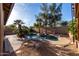 Backyard pool is surrounded by lush landscaping and trees at 11402 W Hadley St, Avondale, AZ 85323