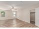 This bedroom features wood-look floors, a ceiling fan, and natural light from the windows at 11538 W Windrose Ave, El Mirage, AZ 85335