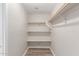 Walk-in closet with wood-look floors and built in shelving for easy storage at 11538 W Windrose Ave, El Mirage, AZ 85335