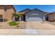 Charming single-story home features a two-car garage, desert landscaping, and mature palm trees at 11538 W Windrose Ave, El Mirage, AZ 85335