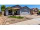 Charming single-story home features a two-car garage, desert landscaping, and mature palm trees at 11538 W Windrose Ave, El Mirage, AZ 85335