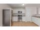Bright kitchen boasts stainless steel appliances and white cabinets, perfect for modern living at 11538 W Windrose Ave, El Mirage, AZ 85335