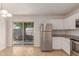 Bright kitchen boasts stainless steel appliances, white cabinets, and access to the backyard at 11538 W Windrose Ave, El Mirage, AZ 85335