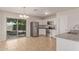 Bright kitchen boasts stainless steel appliances, white cabinets, and view into the backyard at 11538 W Windrose Ave, El Mirage, AZ 85335