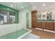 Beautiful bathroom with a tub, shower with green mosaic tiles and modern vanities at 12423 N 64Th St, Scottsdale, AZ 85254