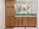 Bathroom featuring custom wood cabinets, double sinks, and quartz countertops at 12423 N 64Th St, Scottsdale, AZ 85254