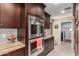 Modern kitchen with stainless steel double ovens, dark wood cabinets, tile backsplash, and marble countertops at 12423 N 64Th St, Scottsdale, AZ 85254