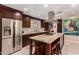 Elegant kitchen featuring stainless steel appliances, a center island with seating, and stylish backsplash at 12423 N 64Th St, Scottsdale, AZ 85254