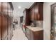Expansive kitchen with dark cabinetry, stainless steel appliances, marble counters, and a door leading outside at 12423 N 64Th St, Scottsdale, AZ 85254