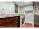 Laundry room with front-loading washer/dryer, granite countertops, and custom cabinets at 12423 N 64Th St, Scottsdale, AZ 85254