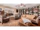 Inviting living room featuring extensive bookshelves and comfortable seating near dining space at 12423 N 64Th St, Scottsdale, AZ 85254