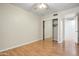 Spacious bedroom with hardwood floors, a mirrored closet, a ceiling fan, and a door leading to another room at 1342 W Emerald Ave # 286, Mesa, AZ 85202