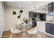 Cozy dining area with a glass-top table, modern white chairs, and views of the adjacent kitchen at 1342 W Emerald Ave # 286, Mesa, AZ 85202
