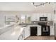 Bright kitchen with white cabinets, grey backsplash, and black appliances at 1653 E Gail Dr, Chandler, AZ 85225