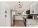 Modern kitchen with white cabinets, stainless steel appliances, and wood flooring at 1653 E Gail Dr, Chandler, AZ 85225