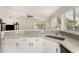 Open kitchen with white cabinets, gray countertops and backsplash, and wood flooring at 1653 E Gail Dr, Chandler, AZ 85225