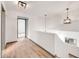 Bright hallway with wood-look flooring, white walls, and modern light fixtures at 16622 S 32Nd Pl, Phoenix, AZ 85048